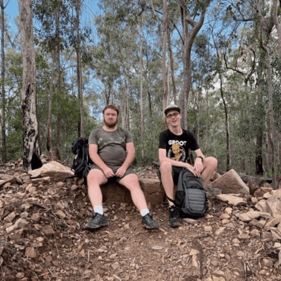 Two participants resting on rocks during a bush hike